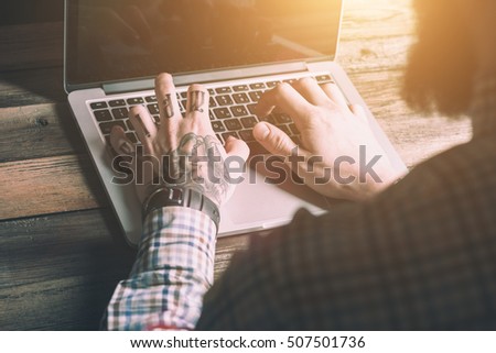 Male Hands With Tattoo Typing On The Keyboard Of A Laptop On Vintage Wooden Table. Mock-up With Laptop