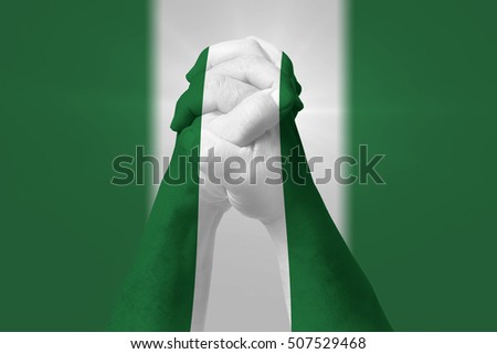 Man clasped hands patterned with the NIGERIA flag