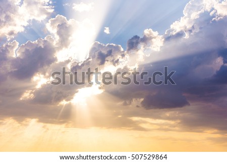 Sun beams or rays breaking through the dark clouds at sunset. Hope, prayer, God's mercy and grace. Beautiful spectacular conceptual meditation background.  Royalty-Free Stock Photo #507529864