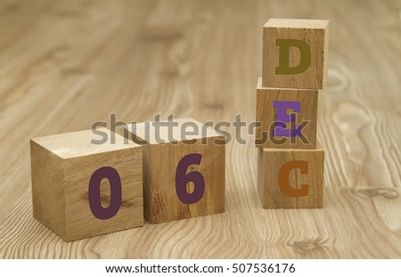 Cube shape calendar for December 06 on wooden surface.