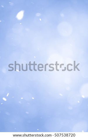Abstract Blue Christmas Background with Real Snow. Blurred Snowflakes Photo.