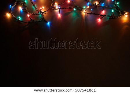 Christmas background with lights and free text space. Christmas lights border. Glowing colorful Christmas lights on black background. New Year. Christmas. Decor. Garland. Royalty-Free Stock Photo #507541861