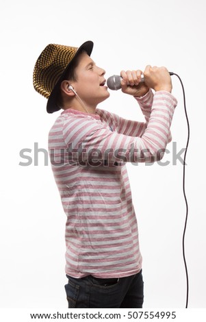 singer brunette boy in a pink jersey in gold hat with a microphone on a white background