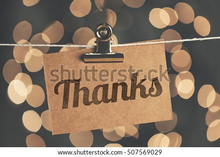 Thanks sign pegged to a string with blurred bokeh lights in the background