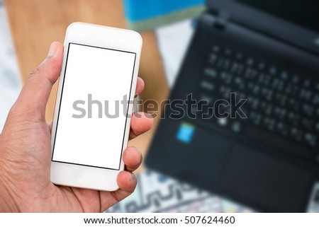 Hand holding mobile smart phone with blank screen in vertical position, blurred background - mockup template