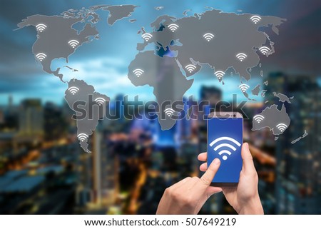 Hand holding mobile phone with wifi icon on world map and city and network connection concept