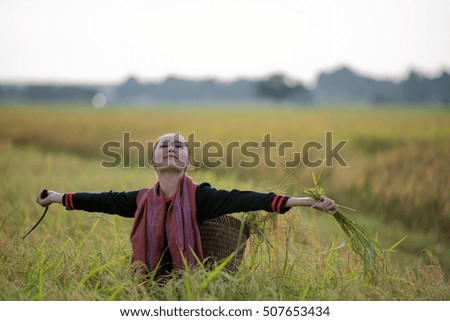 Beautiful young woman in a rural field full of colorful summer flowers as she relaxes and unwinds after an exhausting day in the countryside. Tired, stressed portrait concept