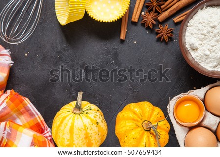 Raw baking ingredients - pumpkin , flour, eggs, cream, cinnamon. On a dark background, top view, copy space. Food background