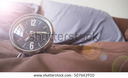 Time to Say good morning on the bed, the alarm clock Royalty-Free Stock Photo #507663910