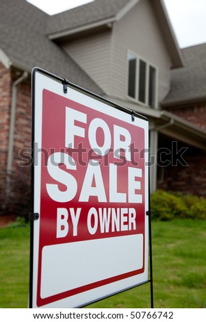 A house with a red for sale sign in the yard