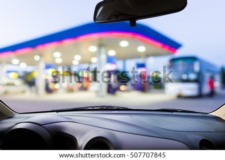 On the windshield , blur image of gas station as background.