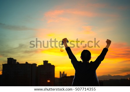 Win concept. Businessman holding gold medal. Royalty-Free Stock Photo #507714355