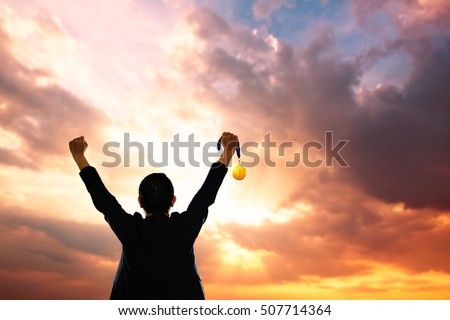 Win concept. Businessman holding gold medal. Royalty-Free Stock Photo #507714364