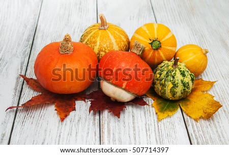 Pumpkins and autumn  leaves on a old wooden table