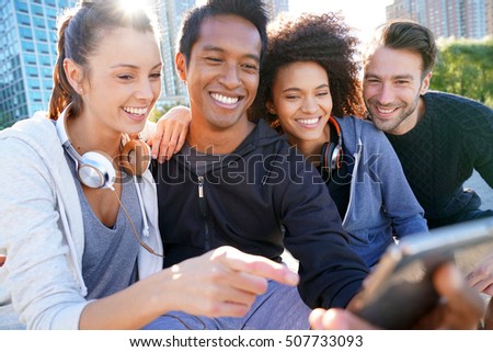 Group of friends in casual outfit taking selfie picture with smartphone