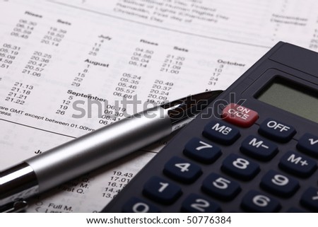 calculator with pen and calculations