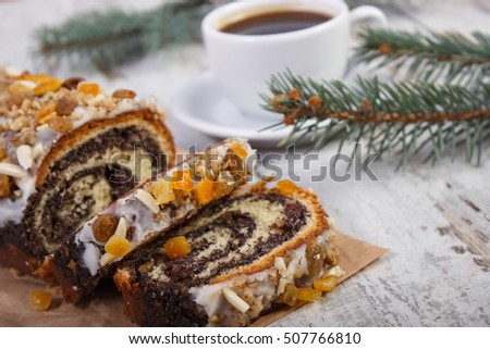 Poppy seeds cake, black coffee and spruce branches on board, dessert and decoration for Christmas, rolled up traditional polish poppy pie