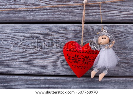 Beautiful little fairy and red wooden heart. Traditional New Year's toys. Christmas holidays.