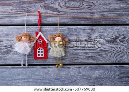 Beautiful fabulous fairies and red house hanging on a wooden fence. Toys for home comfort. Christmas holidays.