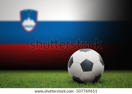 vintage black and white football ball on green grass has the national flag of Slovenia  background