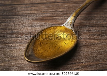 Fish oil in spoon on wooden background