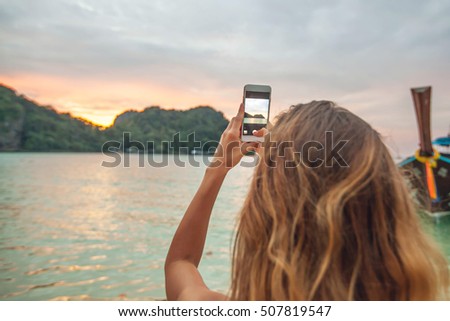 Woman taking photos with smartphone in Thailand