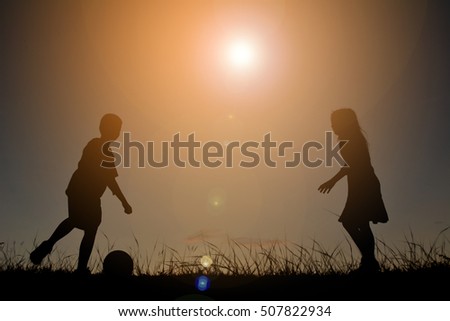 Silhouette children playing football on the sky sunset. Time on holiday happy and fun , vintage tone