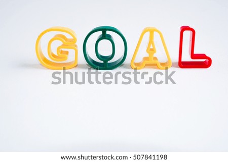 plastic alphabet on white background with word goal