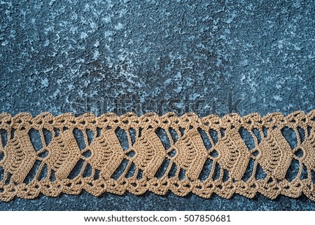 Lace embroidery ribbon on blue framed cement background
