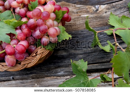 Red grapes in basket on a wooden vintage table background 
