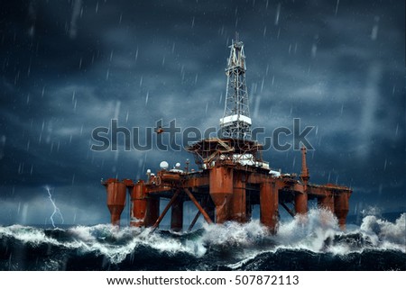 Offshore Oil Platform standing in the middle of ocean sea water during dark heavy rainy day, with high waves and storm Royalty-Free Stock Photo #507872113