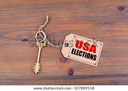 Key and a note on a wooden table with text: USA Elections