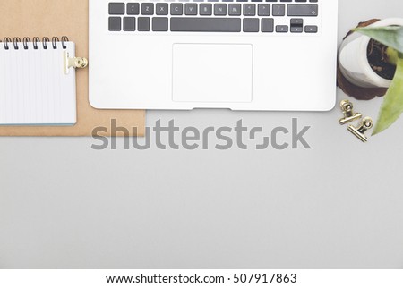 Overhead office desk with laptop notepad and stationary