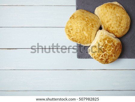 Freshly baked bread rolls on a wooden kitchen table background forming a page border