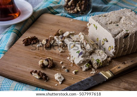Halva Slices with Peanut and tea on a wooden surface.
