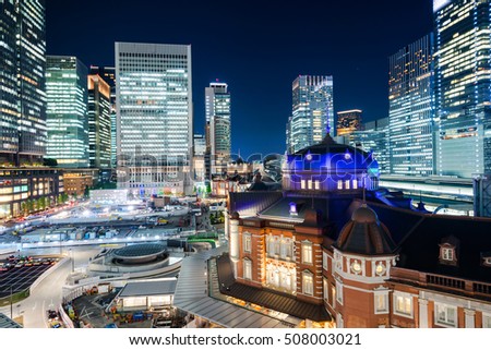 Asian Business concept for real estate and corporate construction - panoramic modern cityscape building bird eye aerial night view of Tokyo Station under neon light and dark blue sky in Tokyo, Japan
