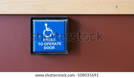 Handicapped access entrance pad mounted to a wall.