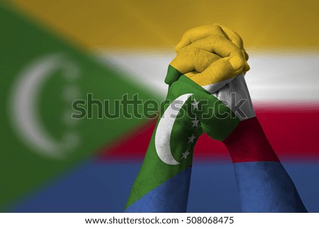 Man clasped hands patterned with the COMOROS flag