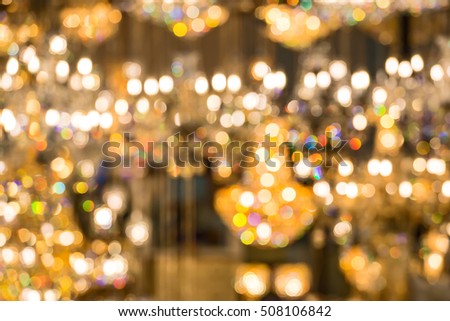 Gold glittering chandeliers lights. Blurred abstract background.