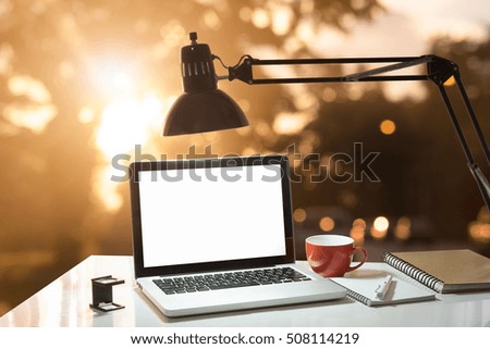 Laptop with blank screen on morning sunshine background,A computer laptop and other gadget on work table, empty screen of laptop, vintage effect.