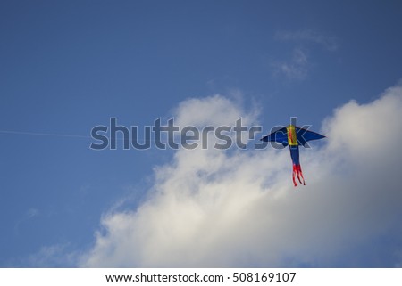 dragon kite flying in a cloudy sky on a bright sunny day