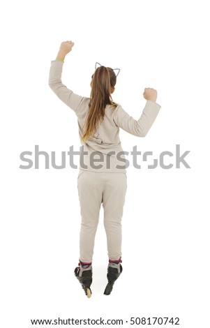Back view of young girl arms up happy on rollers looking at wall. Rear view. Isolated on white background