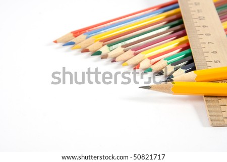 colored pencils and a ruler on a white background