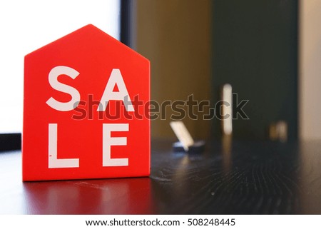 Sale tag on mini home model in red color