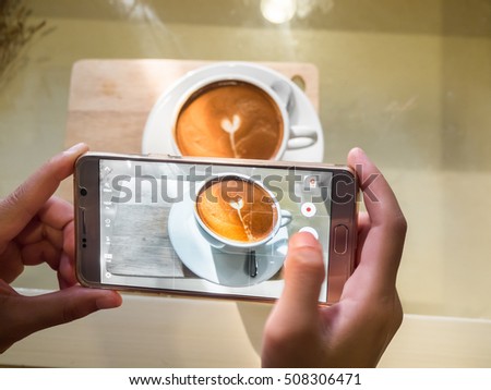 Taking photo before drink coffee with smartphone.