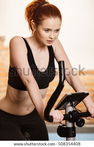 Active young woman doing exercise on bicycle at home. Fitness and weight loss concept.