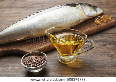 Fish oil with flax grain and fish on wooden background