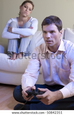 Man playing videogames, woman disappointed and bored