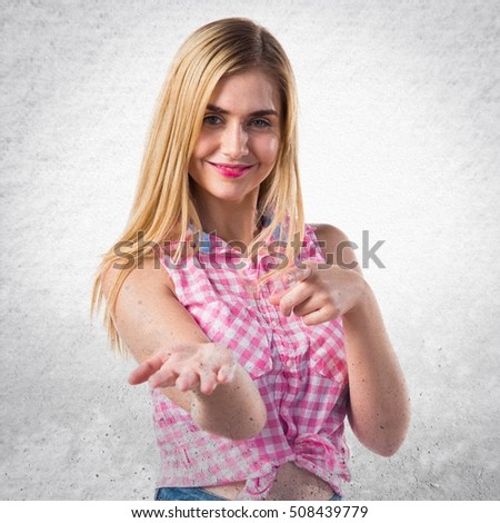 Blonde girl holding something on textured background