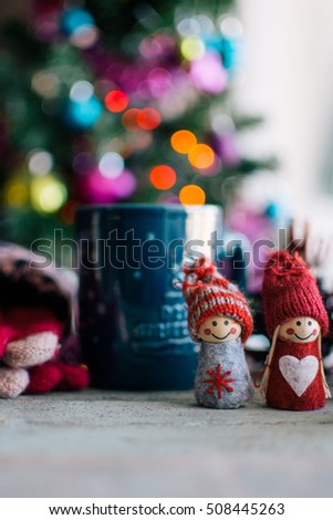 a cup of coffee and knitted dolls with Christmas decoration